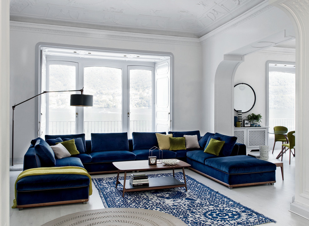 Cette image montre un salon design avec un mur blanc, parquet clair, aucun téléviseur, un sol blanc et éclairage.