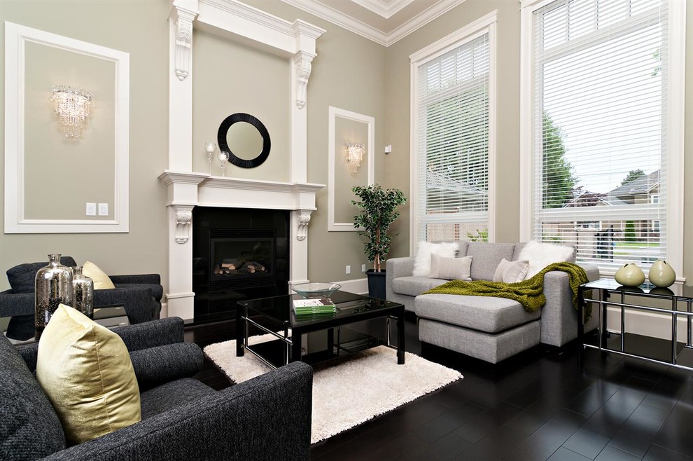 Contemporary living room in Vancouver with grey walls, a standard fireplace and black floors.