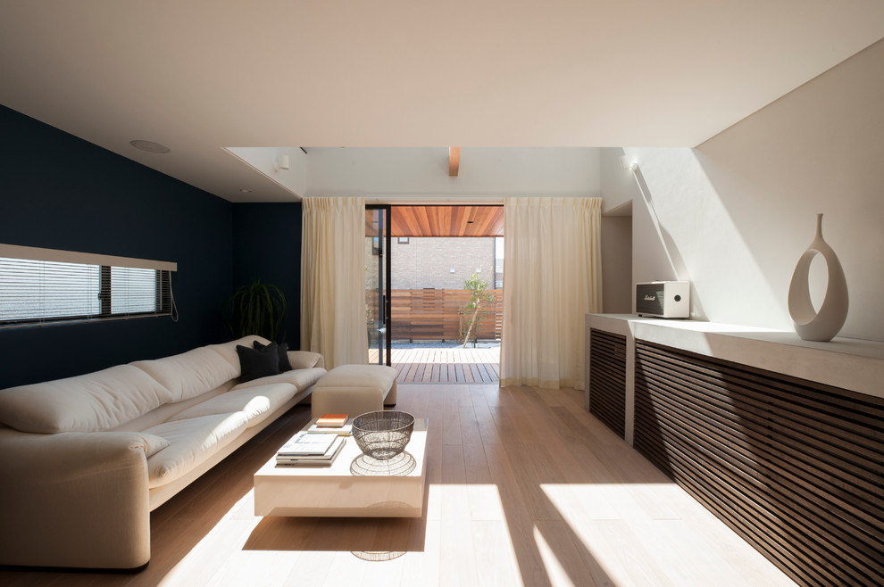 Foto di un soggiorno minimalista con pareti multicolore, pavimento in legno verniciato e pavimento beige