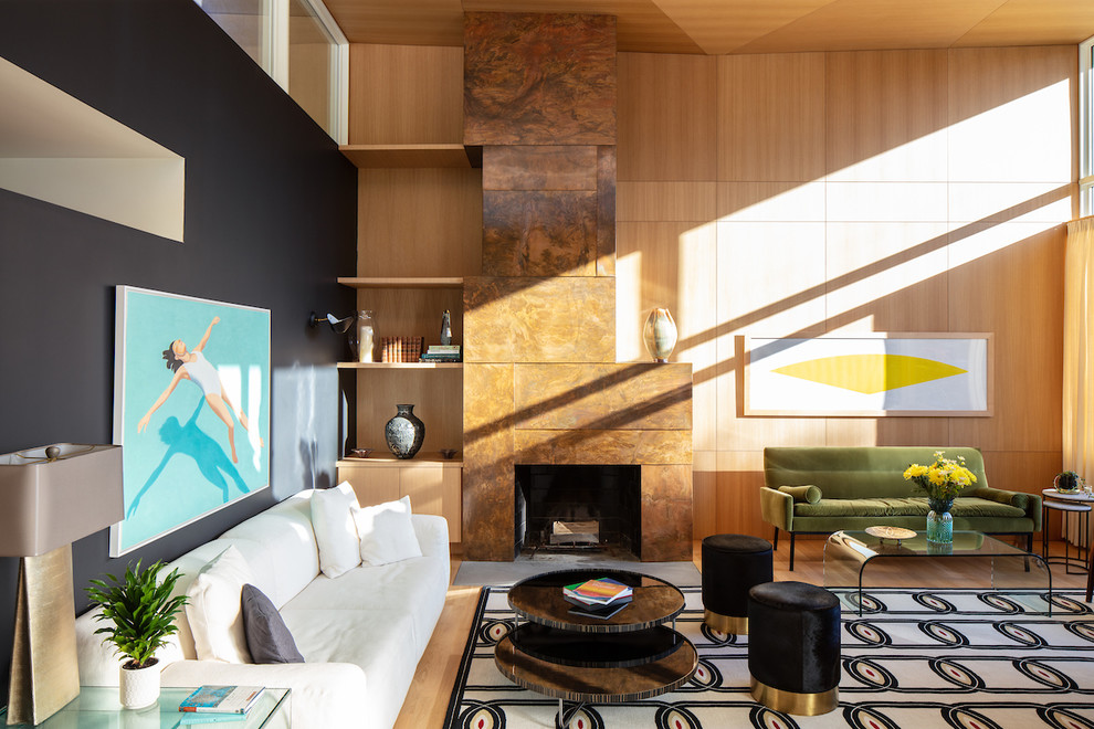 Réalisation d'un salon design avec un mur noir, un sol en bois brun, une cheminée standard, un manteau de cheminée en pierre et un sol marron.