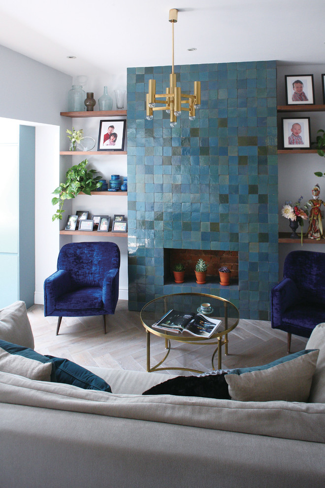 Fernseherloses, Mittelgroßes Modernes Wohnzimmer mit hellem Holzboden, gefliester Kaminumrandung, weißem Boden und weißer Wandfarbe in London