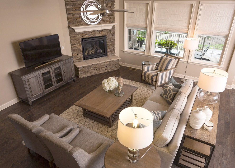 This is an example of a large beach style open plan living room in Cincinnati with grey walls, medium hardwood flooring, a corner fireplace and a stone fireplace surround.