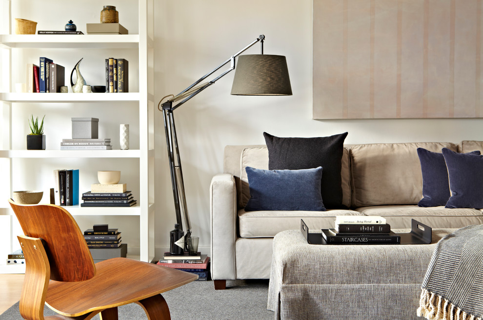 Ispirazione per un soggiorno design di medie dimensioni e aperto con pareti bianche, parquet chiaro e TV autoportante