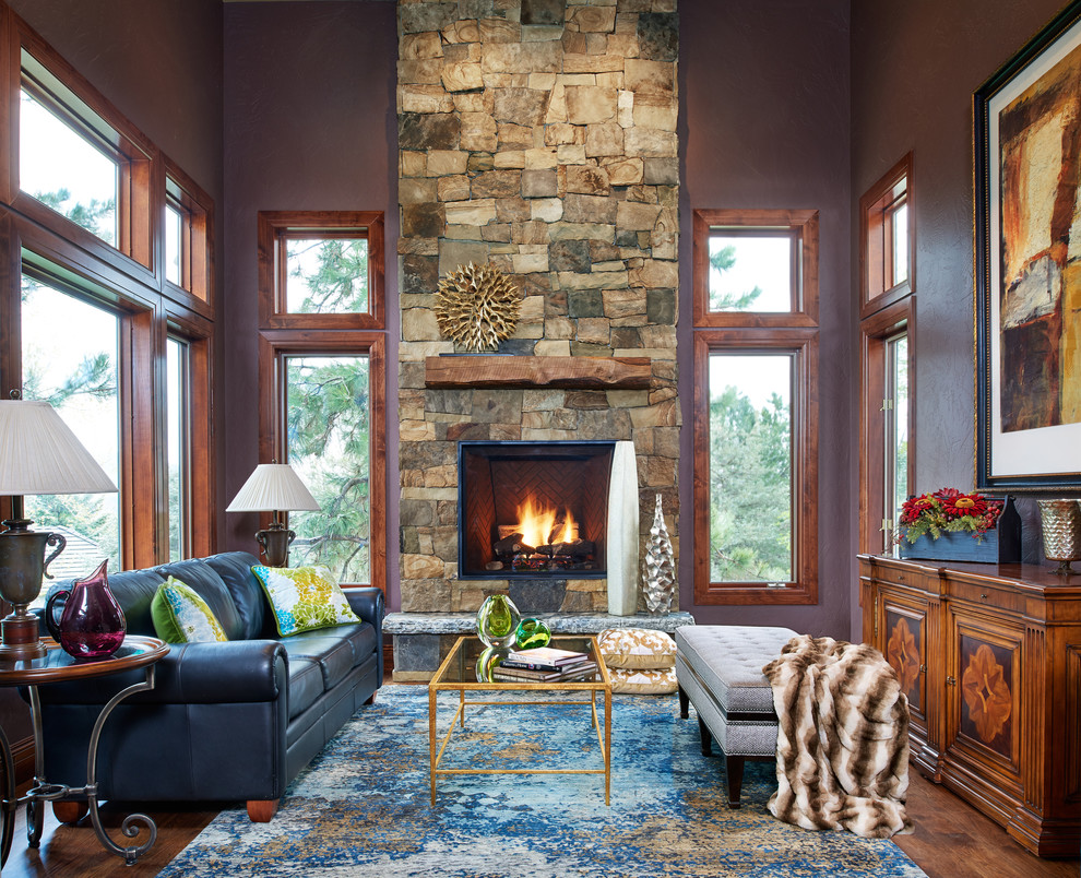 Inspiration for a large rustic formal enclosed living room in Denver with purple walls, medium hardwood flooring, a standard fireplace, a stone fireplace surround and no tv.