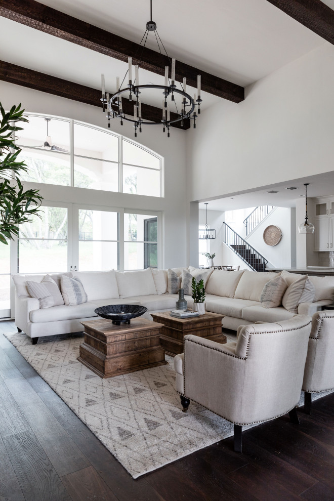 This is an example of an expansive mediterranean open plan living room in Sacramento with white walls, dark hardwood flooring and brown floors.