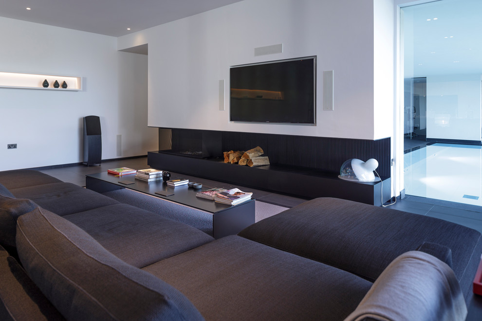 チェシャーにあるラグジュアリーな広いコンテンポラリースタイルのおしゃれなLDK (白い壁、磁器タイルの床、横長型暖炉、金属の暖炉まわり、壁掛け型テレビ、黒い床) の写真
