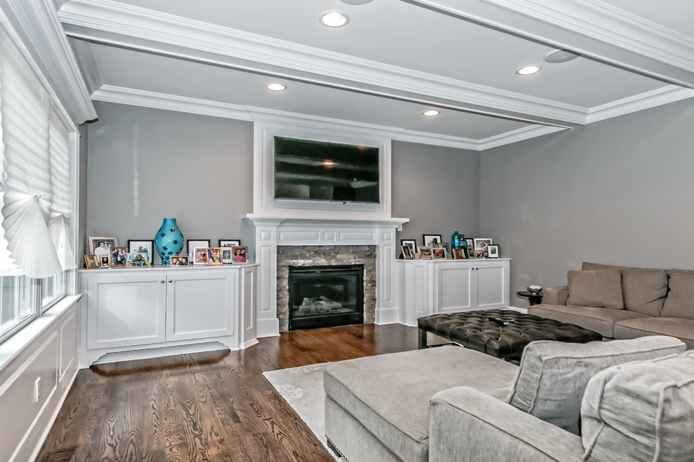 Large minimalist open concept medium tone wood floor living room photo in New York with gray walls, a standard fireplace, a stone fireplace and a wall-mounted tv