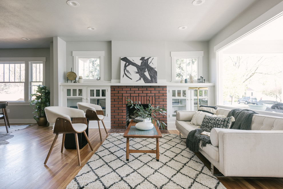 Fernseherloses, Offenes Klassisches Wohnzimmer mit beiger Wandfarbe, Kamin, Kaminumrandung aus Backstein und braunem Boden in Denver