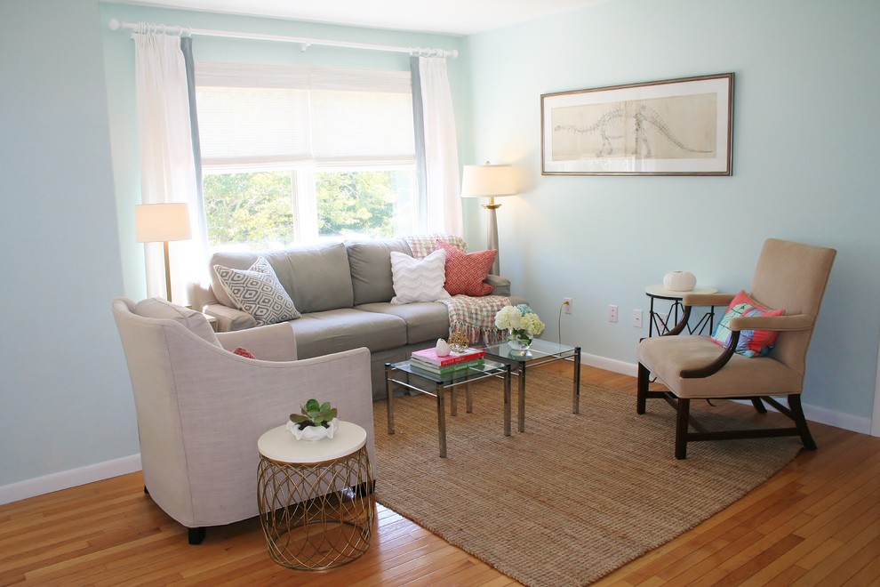 Immagine di un piccolo soggiorno chic chiuso con pareti blu, pavimento in legno massello medio, nessun camino e nessuna TV