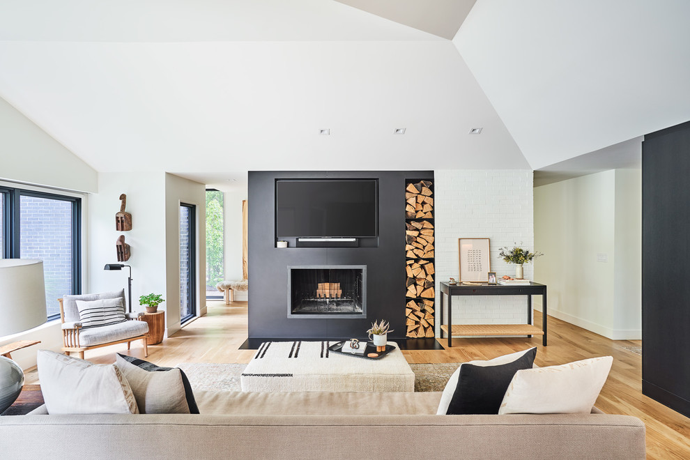 Modernes Wohnzimmer mit schwarzer Wandfarbe, hellem Holzboden, Kamin, TV-Wand und braunem Boden in Kansas City