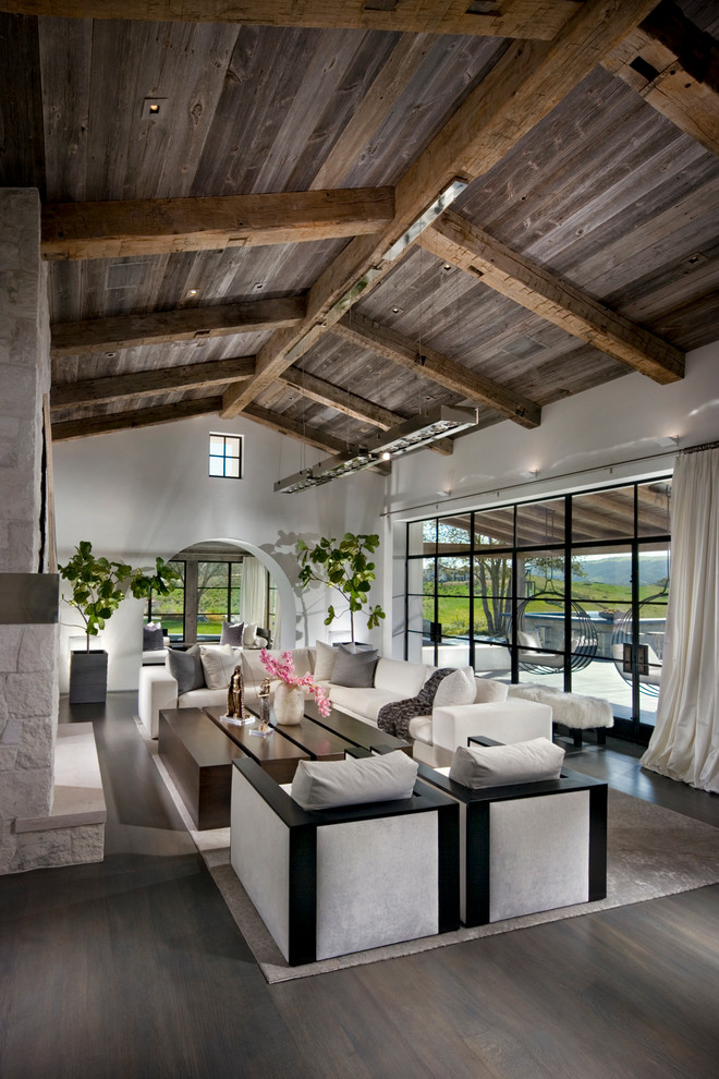 Example of a huge tuscan open concept medium tone wood floor living room design in Orange County with a two-sided fireplace and a stone fireplace