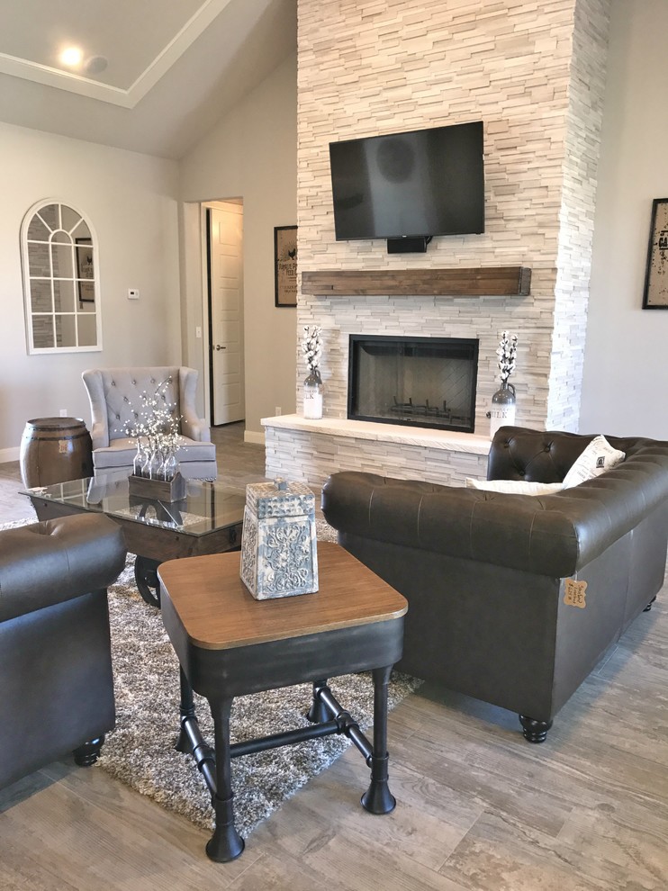 Example of a large farmhouse open concept porcelain tile and multicolored floor living room design in Dallas with gray walls, a standard fireplace, a stone fireplace and a wall-mounted tv