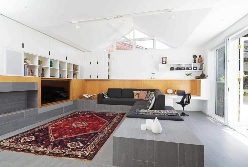 На фото: открытая гостиная комната среднего размера в скандинавском стиле с белыми стенами, горизонтальным камином, фасадом камина из плитки, полом из керамической плитки, мультимедийным центром и серым полом с