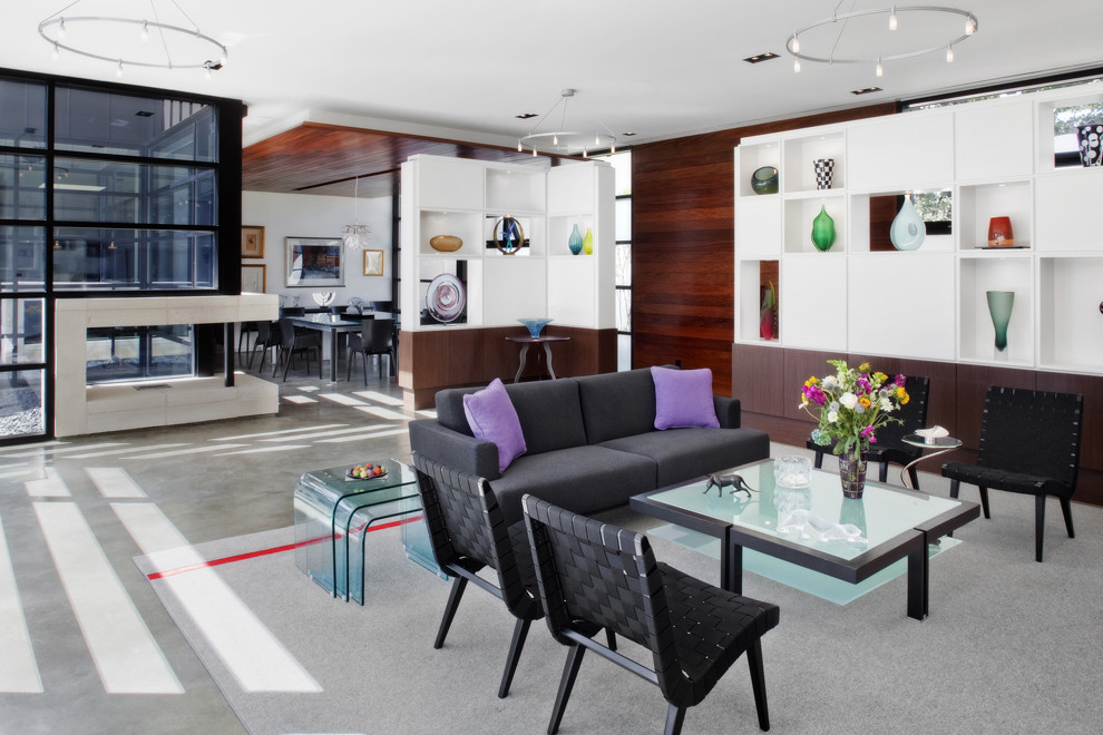 Cette image montre un salon minimaliste avec sol en béton ciré et canapé noir.