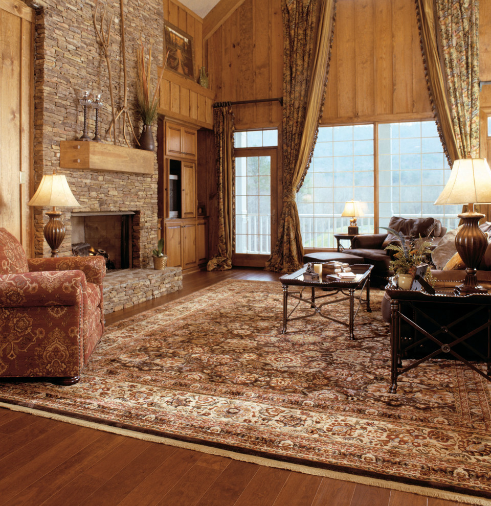 Photo of a large rustic formal enclosed living room in San Francisco with brown walls, dark hardwood flooring, a standard fireplace, a stone fireplace surround, no tv and brown floors.