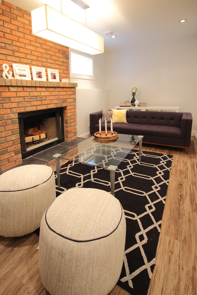 Foto di un piccolo soggiorno moderno aperto con pareti bianche, pavimento in vinile, camino classico, cornice del camino in mattoni e pavimento marrone