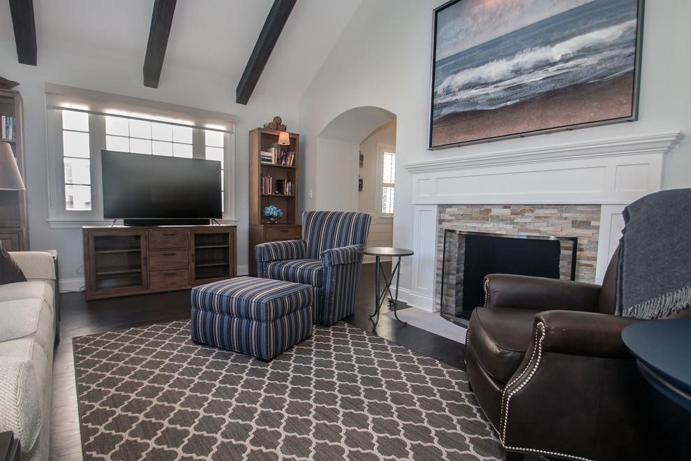 Mid-sized beach style enclosed dark wood floor and gray floor living room photo in Milwaukee with gray walls, a standard fireplace, a stone fireplace and a tv stand