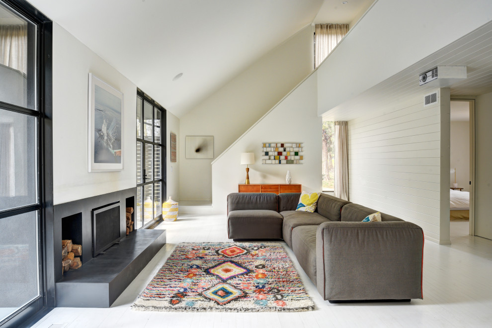 Offenes Modernes Wohnzimmer mit weißer Wandfarbe, gebeiztem Holzboden, Kamin, weißem Boden, gewölbter Decke und Holzdielenwänden in New York