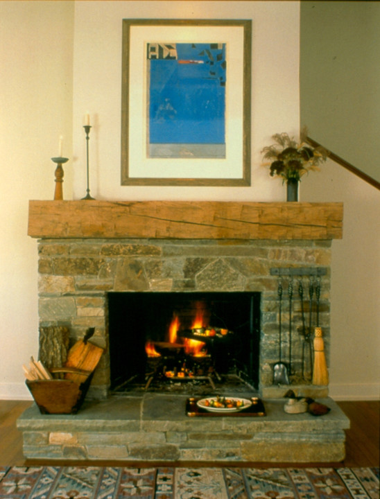 Example of a large eclectic medium tone wood floor living room design in New York with white walls, a standard fireplace, a stone fireplace and no tv