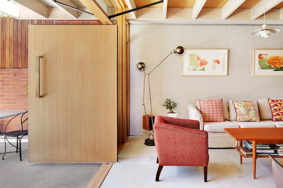 Стильный дизайн: парадная гостиная комната в стиле ретро с бежевыми стенами и бетонным полом - последний тренд