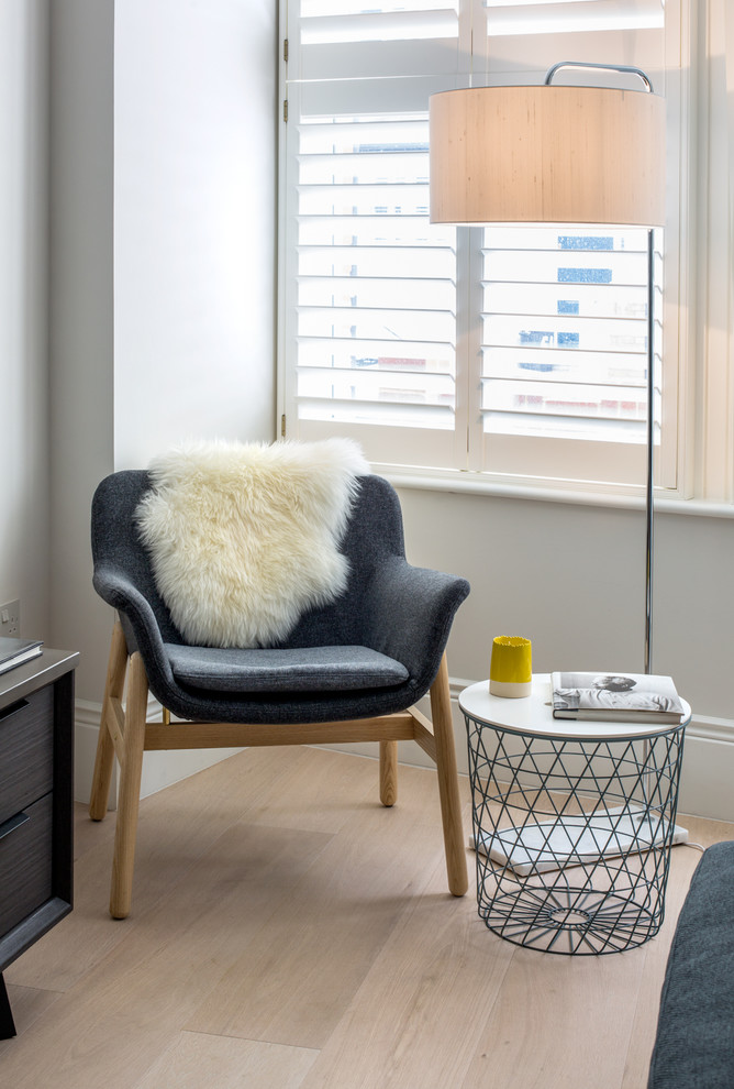 Small contemporary open plan living room in London with white walls and light hardwood flooring.