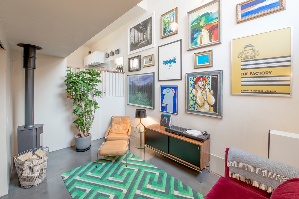 Foto på ett minimalistiskt separat vardagsrum, med ett finrum, beige väggar, betonggolv, en öppen vedspis och grått golv
