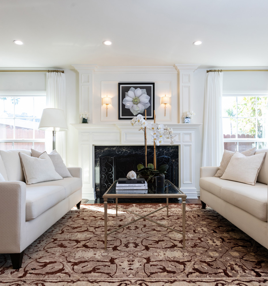 ロサンゼルスにある高級な広いトランジショナルスタイルのおしゃれなLDK (白い壁、無垢フローリング、標準型暖炉、木材の暖炉まわり、茶色い床、羽目板の壁) の写真
