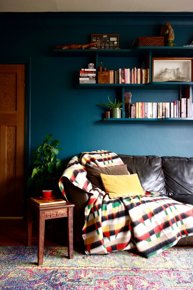 Großes, Offenes Eklektisches Wohnzimmer ohne Kamin mit grüner Wandfarbe, braunem Holzboden, verputzter Kaminumrandung und freistehendem TV in Sonstige
