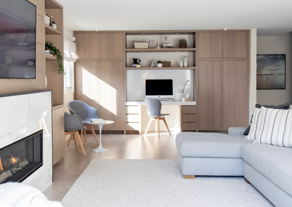 Ispirazione per un soggiorno moderno aperto con pavimento in legno massello medio, cornice del camino in pietra e TV a parete