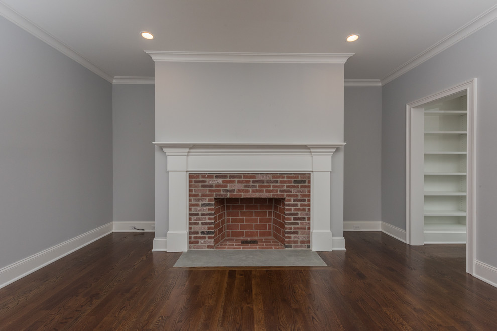 Photo of a medium sized traditional open plan living room in Bridgeport with grey walls, dark hardwood flooring, a standard fireplace, a brick fireplace surround, a wall mounted tv and brown floors.