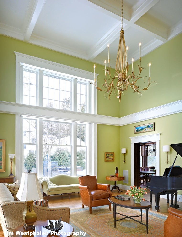 Источник вдохновения для домашнего уюта: большая парадная, двухуровневая гостиная комната в классическом стиле с зелеными стенами, паркетным полом среднего тона, стандартным камином и фасадом камина из камня