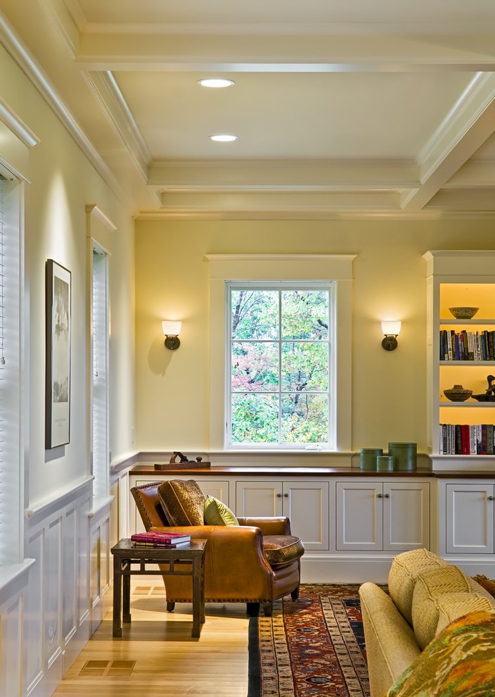 Example of an ornate living room library design in Burlington with yellow walls