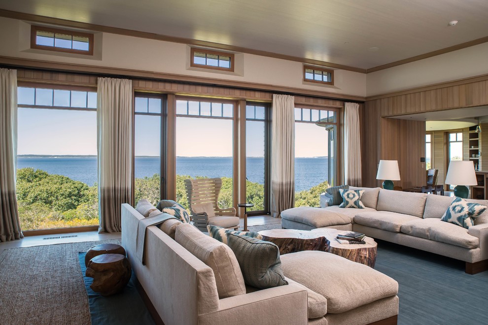 This is an example of an expansive beach style living room in Boston with beige walls and beige floors.