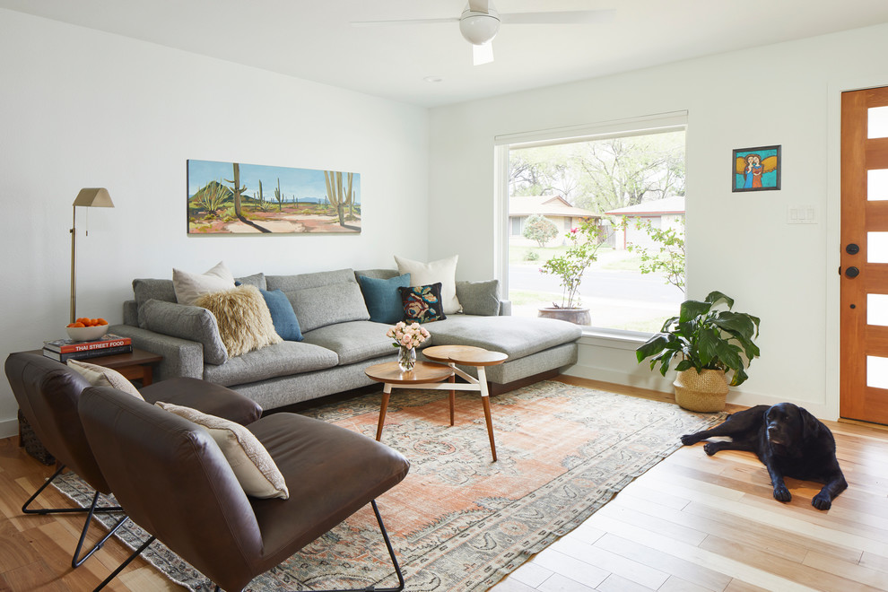 Bild på ett mellanstort retro allrum med öppen planlösning, med vita väggar, ljust trägolv, en fristående TV och brunt golv