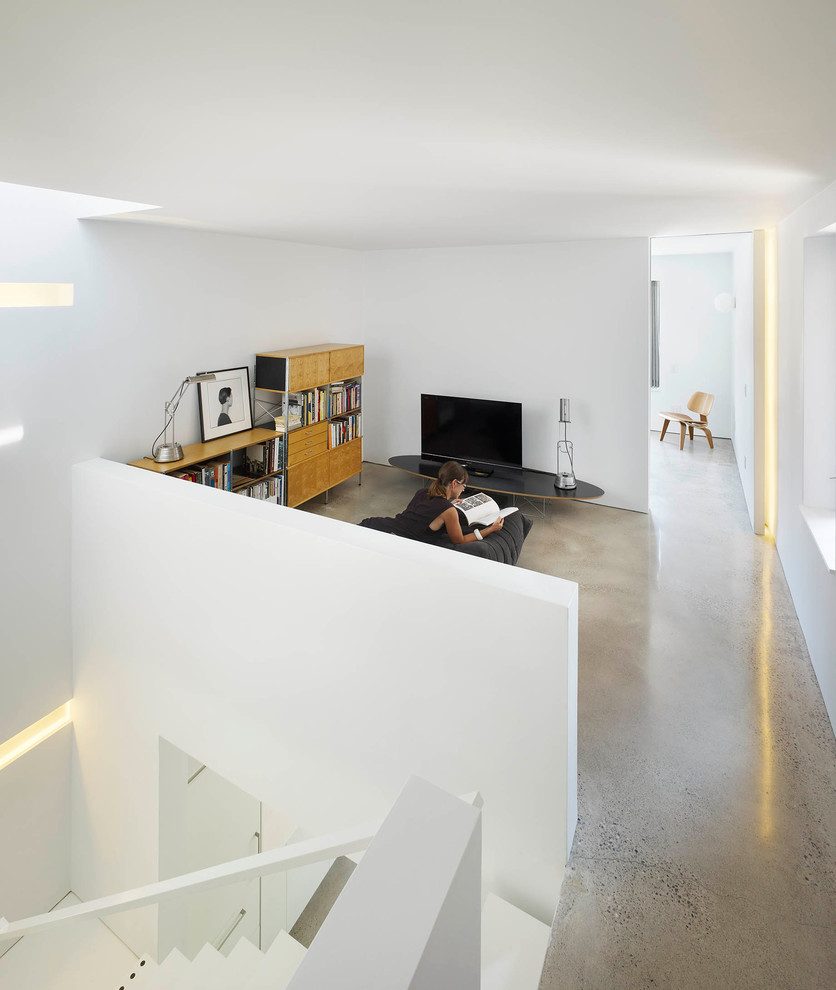 Ispirazione per un piccolo soggiorno minimalista aperto con pareti bianche e pavimento in cemento