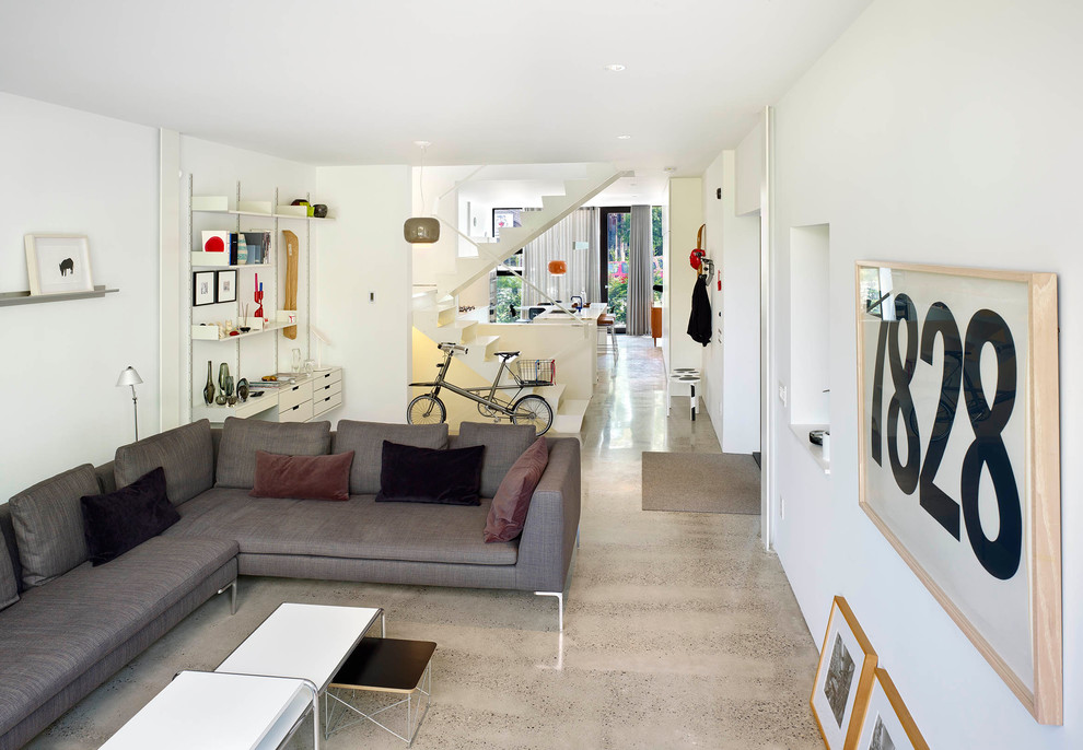 Esempio di un piccolo soggiorno minimalista aperto con pareti bianche e pavimento in cemento