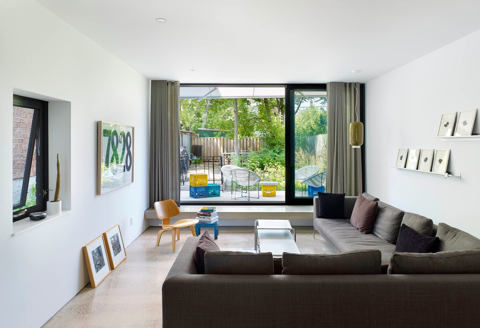 Immagine di un piccolo soggiorno minimalista aperto con pareti bianche e pavimento in cemento