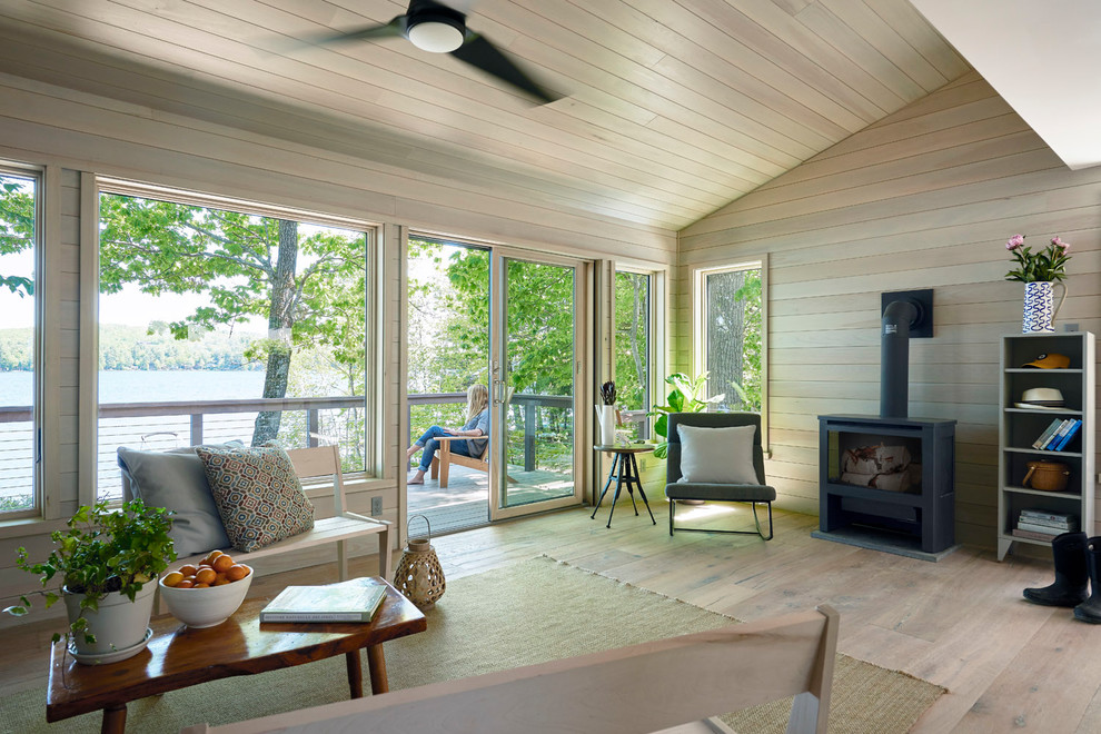 Mittelgroßes, Abgetrenntes, Fernseherloses Maritimes Wohnzimmer mit hellem Holzboden, beigem Boden, beiger Wandfarbe und Kaminofen in Portland Maine