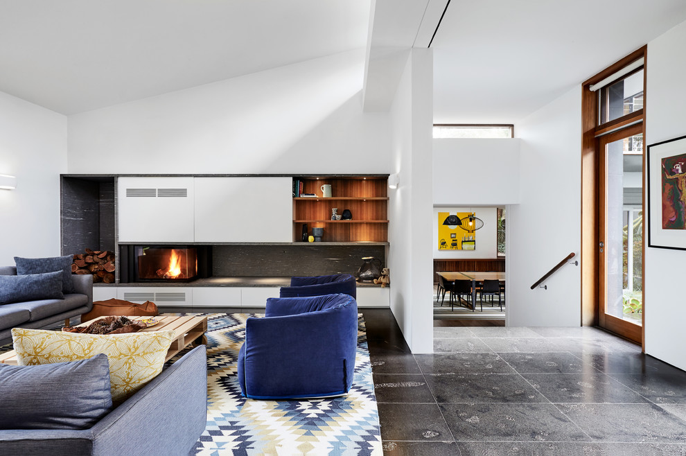 Repräsentatives Modernes Wohnzimmer mit weißer Wandfarbe, Eckkamin, Kaminumrandung aus Stein, Multimediawand und schwarzem Boden in Melbourne