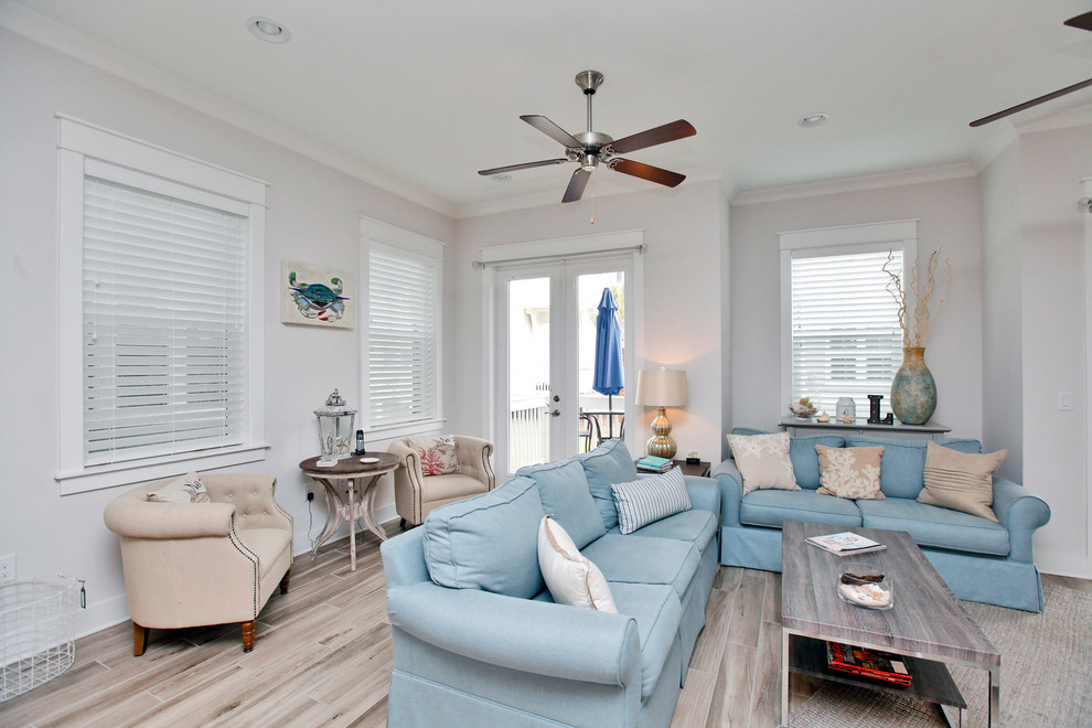 Photo of a medium sized beach style open plan living room in San Diego with light hardwood flooring, a wall mounted tv and grey walls.