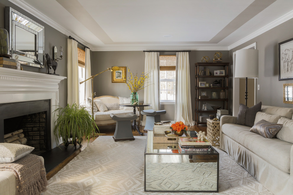 На фото: изолированная гостиная комната в классическом стиле с серыми стенами, темным паркетным полом, стандартным камином, фасадом камина из камня и коричневым полом