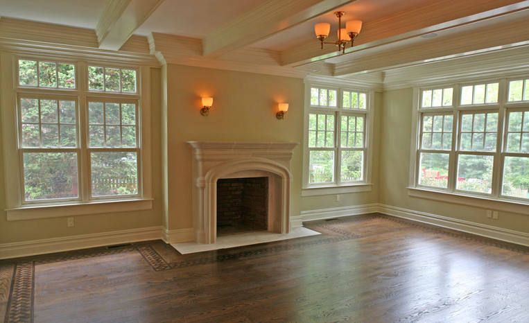 Cette photo montre un salon chic fermé avec un mur beige, un sol en bois brun, une cheminée standard et un manteau de cheminée en pierre.