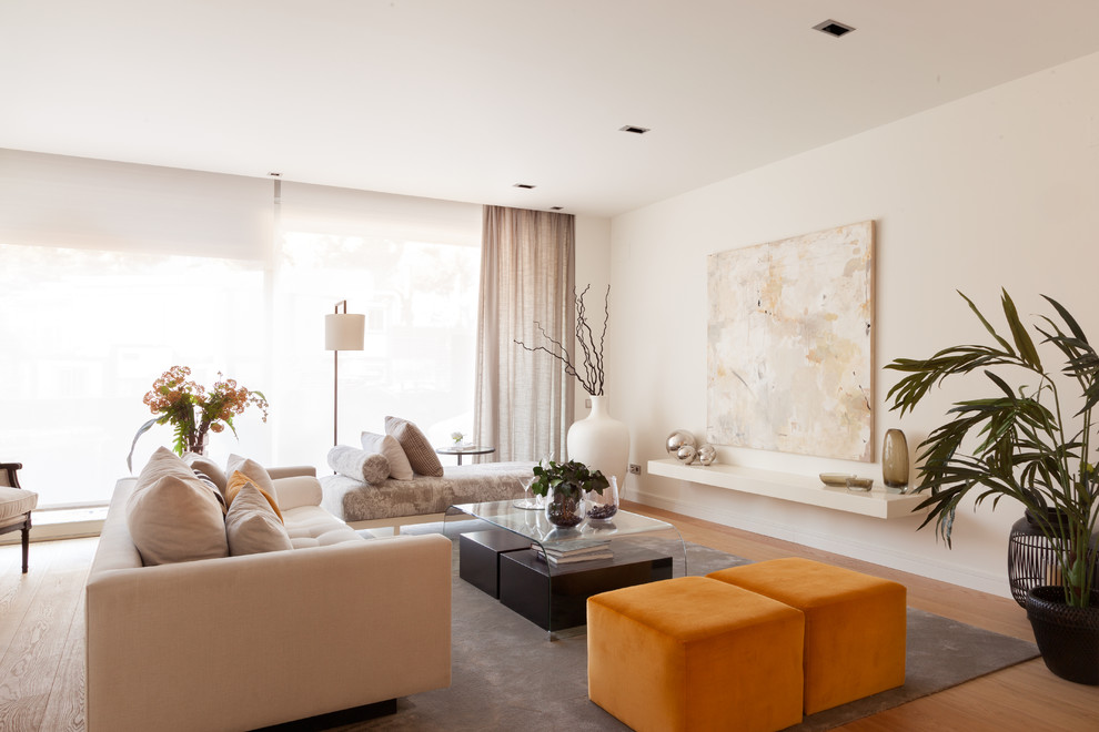 Mittelgroßes, Repräsentatives, Fernseherloses, Offenes Eklektisches Wohnzimmer ohne Kamin mit weißer Wandfarbe und braunem Holzboden in Madrid