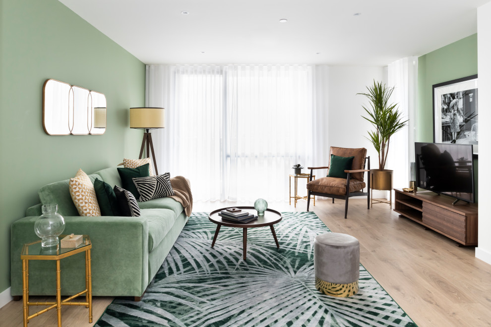 Kleines Modernes Wohnzimmer ohne Kamin mit grüner Wandfarbe, braunem Holzboden, freistehendem TV und braunem Boden in London