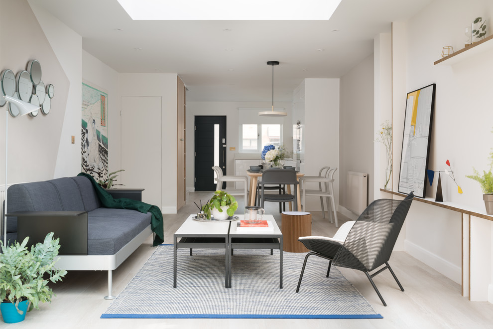 Inredning av ett modernt mellanstort separat vardagsrum, med blå väggar, ljust trägolv, en standard öppen spis och beiget golv