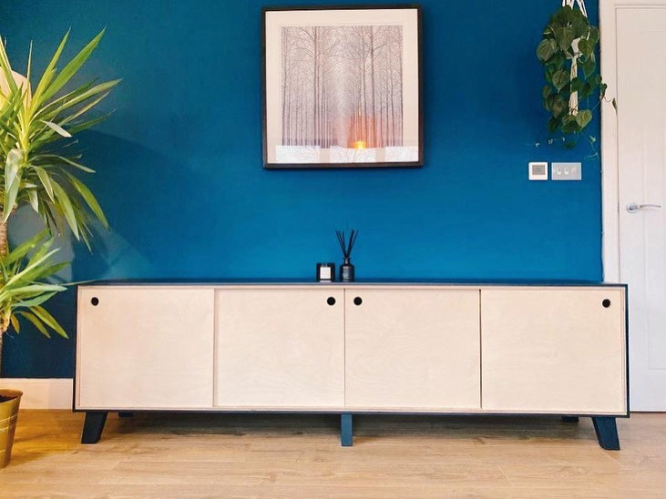 Mittelgroßes, Offenes Modernes Wohnzimmer mit blauer Wandfarbe, Laminat und freistehendem TV in Surrey