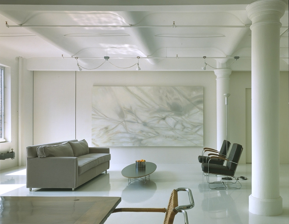 This is an example of a large contemporary mezzanine living room in New York with white walls, concrete flooring, no fireplace and no tv.