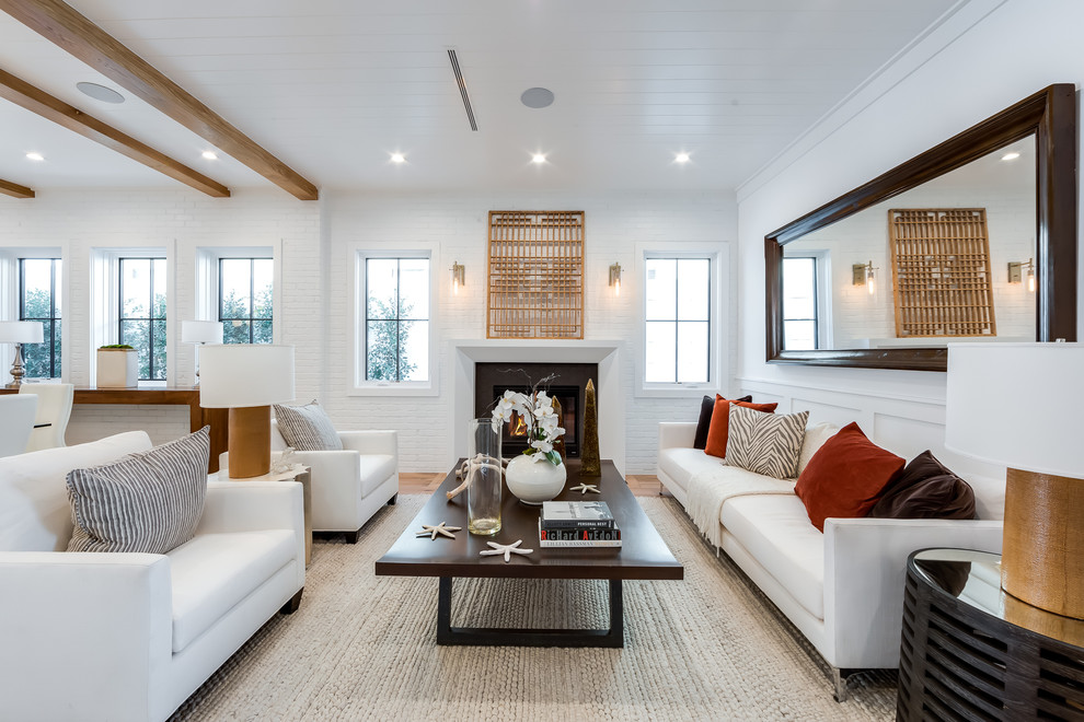 Foto di un soggiorno stile marinaro aperto con pareti bianche, parquet chiaro, camino classico e pavimento marrone