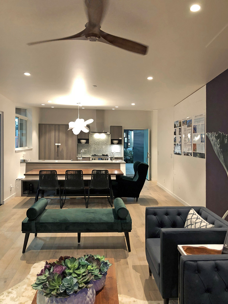 Mittelgroßes, Fernseherloses, Offenes Modernes Wohnzimmer mit weißer Wandfarbe, hellem Holzboden, Gaskamin, verputzter Kaminumrandung und braunem Boden in Los Angeles