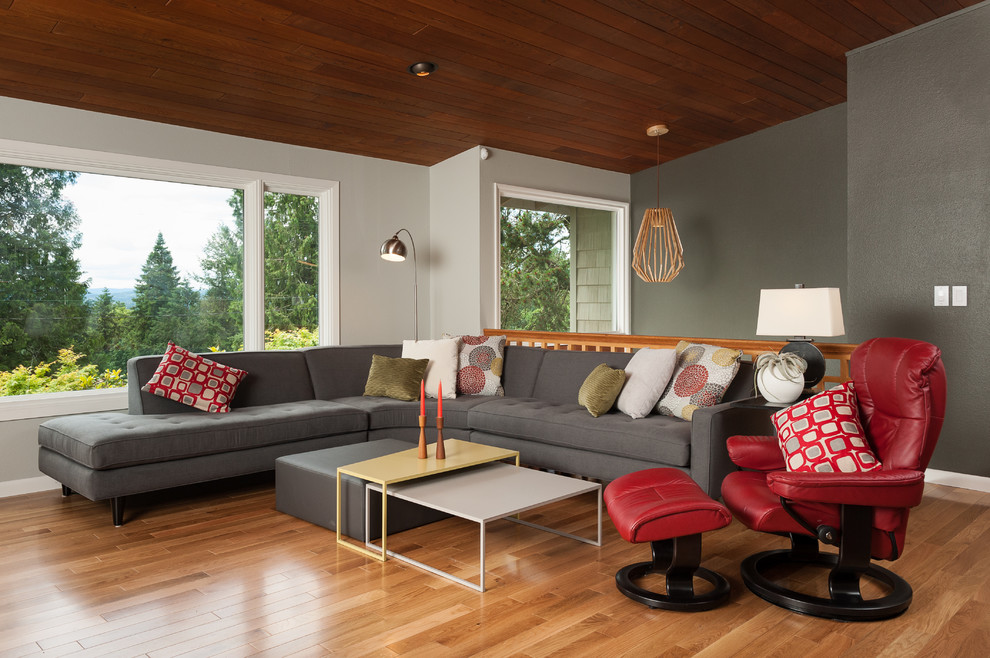 На фото: большая открытая гостиная комната в стиле ретро с серыми стенами, коричневым полом и паркетным полом среднего тона с